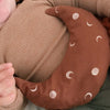 Baby met warmtekussen 'To the Moon Brown' op buikje, gevuld met 100% biologische gereinigde kersenpitten van Warmtemaantje